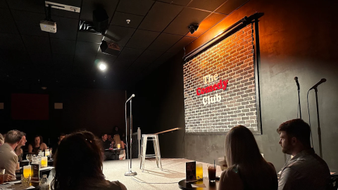 Patrons seated at tables at a comedy club