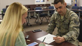 Megan Doty (left), 628th Security Forces Squadron unit program coordinator, files out her travel voucher with Senior Airman James Hauck, 628th Comptroller Squadron financial technician.