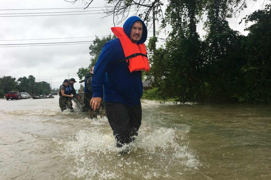 Rene Galvan pulls a boat holding his family members. "We're trying to get my family out. Save 'em," he says. "Help to bring my family back home."