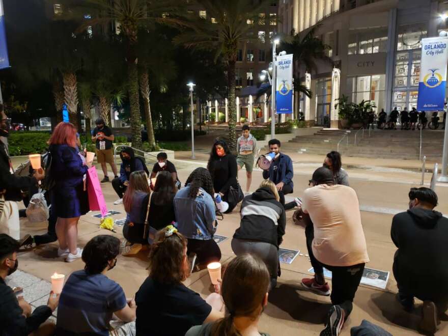 Maxwell Frost, with megaphone, speaks to people during a vigil for George Floyd outside Orlando City Hall on Tuesday April 20th, 2021. Photo: Matthew Peddie, WMFE