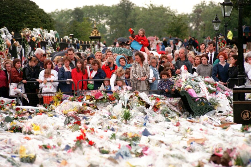 Thousands of mourners gather on Sept. 3, 1997, to lay flowers and cards atop the immense mound of flowers at the gates of Kensington Palace in London, the official residence of Diana, Princess of Wales.