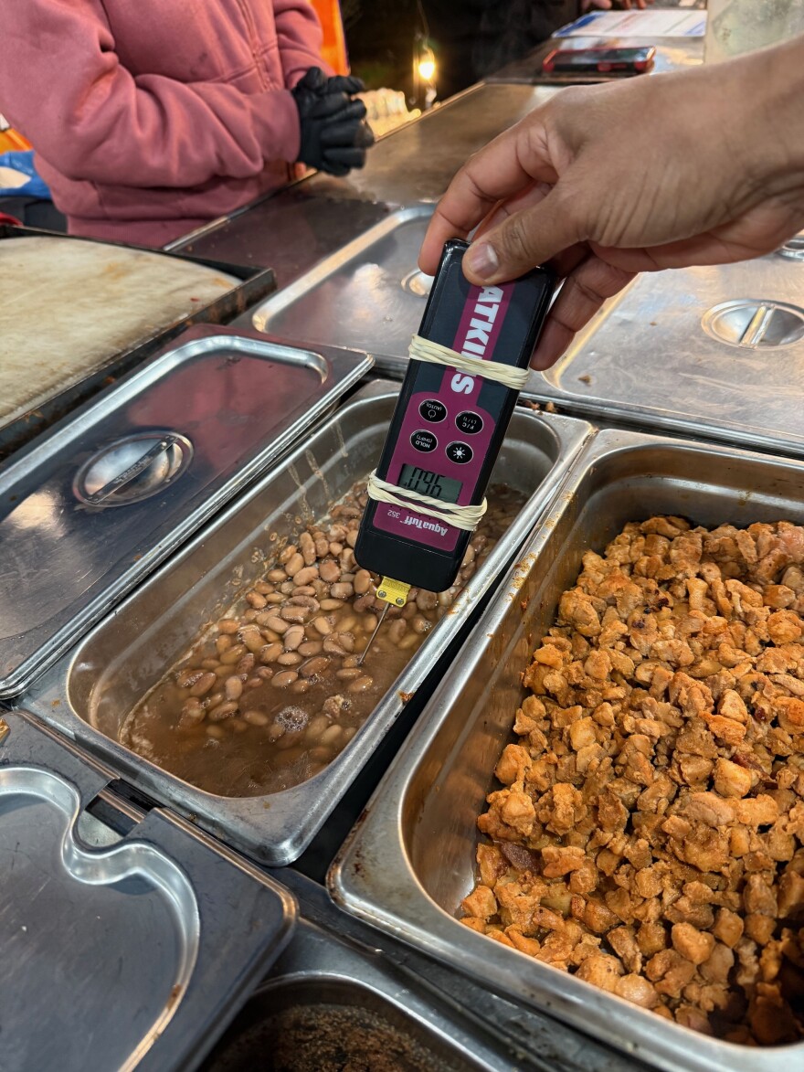 Snohomish County health inspector measure the temperature of beans at an unpermitted food stand on Dec. 11, 2025. 