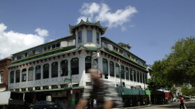 In this May 17, 2007, file photo, a bicyclist rides past the Wo Fat building in Honolulu's Chinatown.