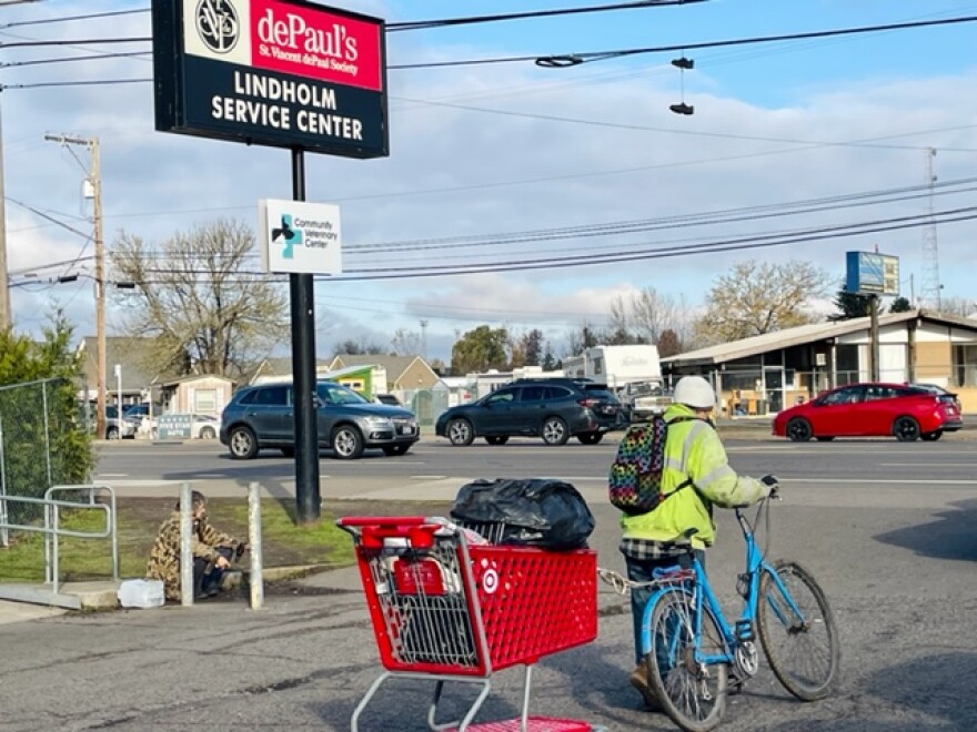 A man leaves the Lindholm Center on busy Hwy 99 N., carting his belongings after having a holiday meal hosted by Eugene Police Department.