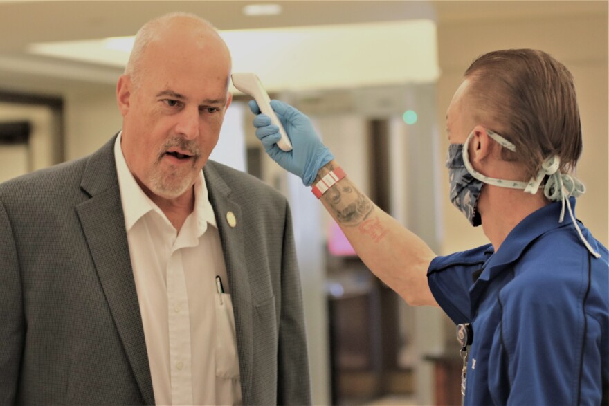 McPherson Republican state Rep. Les Mason gets his temperature checked as he enters the Statehouse during the special session.