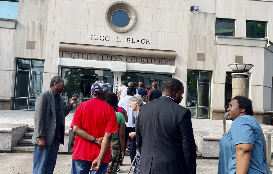 A line of people wait outside the federal courthouse in Birmingham, Ala., on Aug. 14 for a hearing to consider new congressional districts. Federal judges had ruled that the state's 2022 district map diluted Black voters' power.