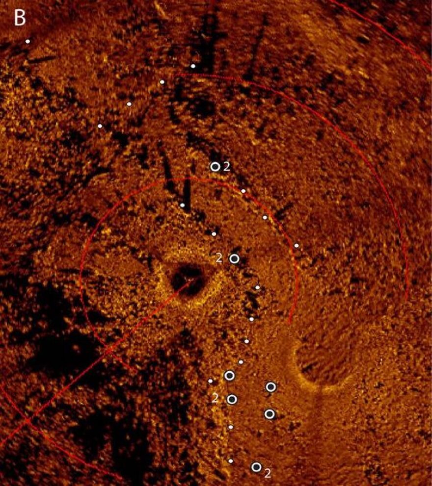 This is an acoustic sonar image of Drop 45 produced from a mosaic of scanning sonar images. The white circles identify locations where they looked for archaeological debris. (courtesy: John O’Shea, University of Michigan)