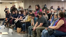A woman speaks at a microphone during the Floyd County Library board of trustees meeting Monday. Also pictured are many of the more than 100 people also in attendance. 
