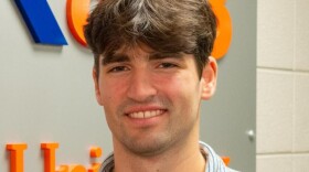 Content Producer Dean Goodchild stands in front of the WAER newsroom.