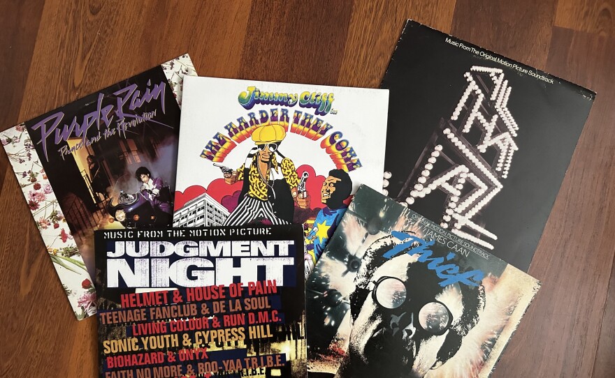 A collection of five movie soundtracks on vinyl spread out on the floor.