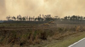  A member of the Florida Forest Service clears flammable debris from a field that's in the path of the Bertha Swamp Road Fire in Calhoun County on Tuesday, March 8, 2022.