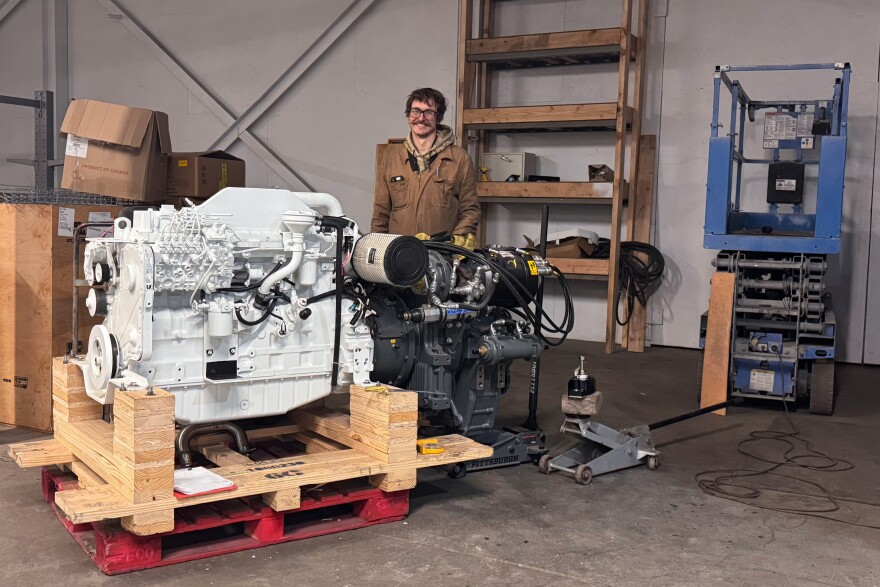 Ben Matthys stands behind the hybrid engine.