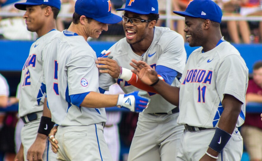 Josh Tobias (right) and Buddy Reed (center) greet second baseman Dalton Guthrie during the opening ceremony of Saturday's game against FSU for the 2015 Gainesville Super Regional.