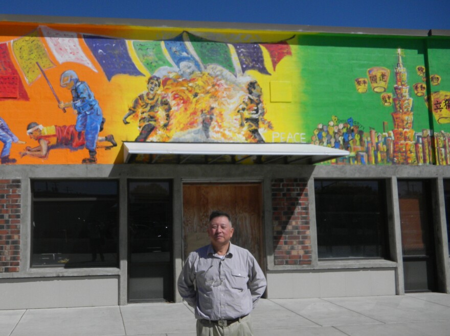 Businessman David Lin stands in front of a mural depicting a self-immolating monk he commissioned in Corvallis, Ore. The Chinese consulate in San Francisco sent a letter to Corvallis' mayor requesting the mural's removal.