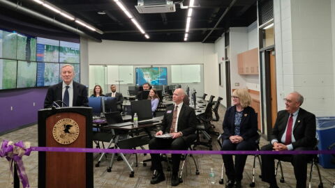 U.S. Senator Dick Durbin (at the podium) addresses the crowd at the ribbon-cutting ceremony. Jamie Johnson, Director of the School of Law Enforcement and Justice Administration; WIU President Kristi Mindrup; and Macomb Mayor Mike Inman (seated left to right in the foreground) were also there along with faculty and students seated in the background.