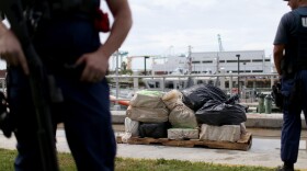 U.S. Coast Guard members stand near bags containing approximately 719 kilograms of cocaine in Miami Beach.