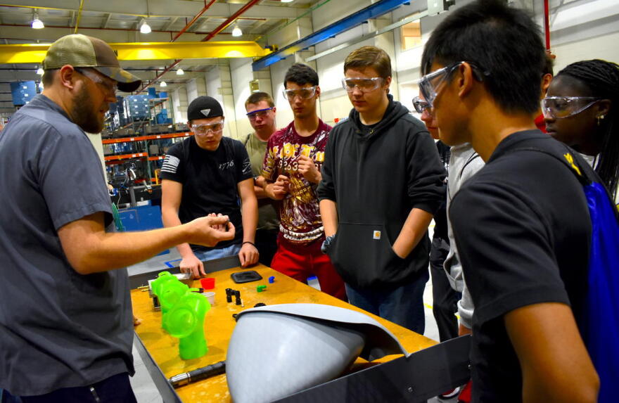 Jeremey Rorie shows Penn High School students what he does for work at B&B Molders in Mishawaka.