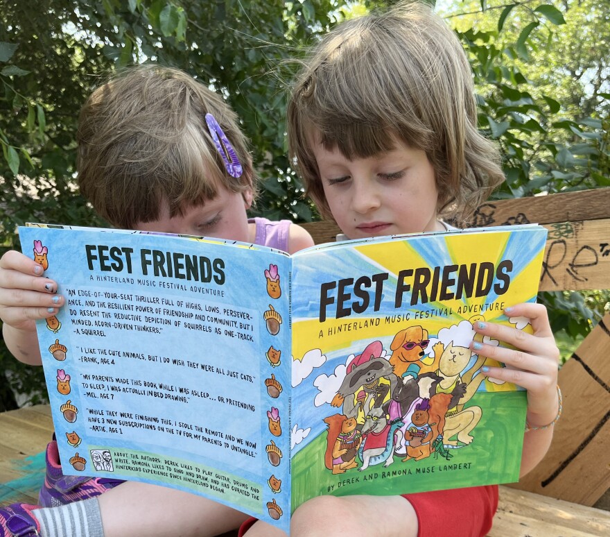 Two young children sitting outside reading a book titled "Fest Friends"