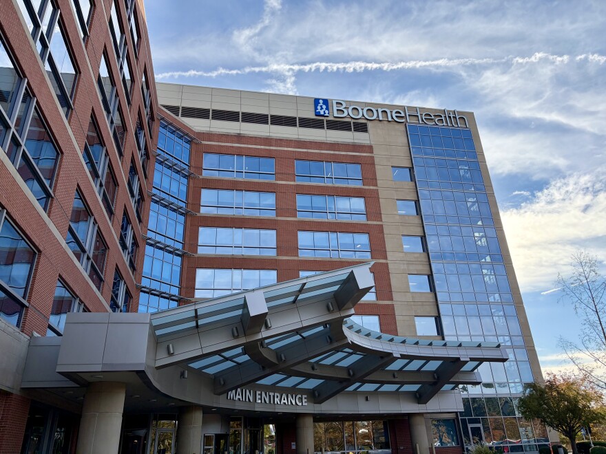 A upward-looking view of the Boone Hospital building in Columbia Missouri. On top of the approximately 6 floors a sign reads "Boone Health"