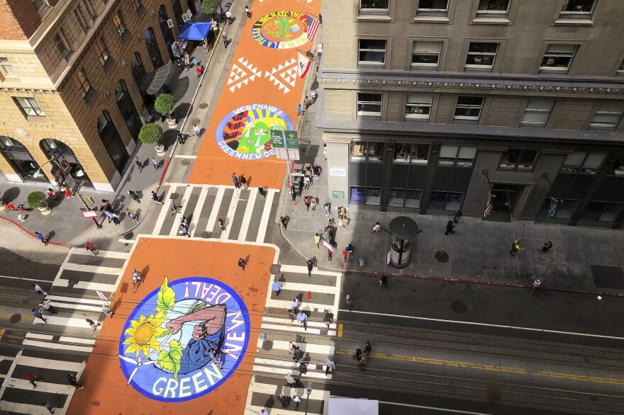 Murals painted by climate activists are seen from an office building on Montgomery Street in San Francisco on Sept. 25.