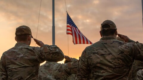 Military personnel salute during a Veterans Day retreat ceremony at Yokota Air Base, Japan, Nov. 9, 2023.