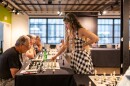 Dorsa Derakhshani stands over a chess board across from her opponent at a St. Louis Chess Club event
