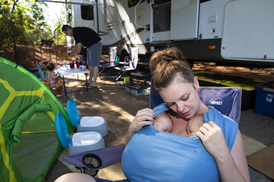 Chelsea holds her newborn twin boys, August and Bishop, while Noah watches Harper and Riley play outside their RV in August. Since the fire, Chelsea, Noah and Chelsea's mother decided to rebuild their home in Paradise, on their same piece of land.