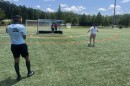 A dozen visually impaired people practice shooting on a soccer field in Matthews.