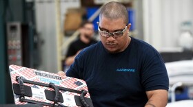 A worker packs a bulletproof whiteboard at the Hardwire factory in Pocomoke City, Maryland, on March 1, 2018. Hardwire makes bulletproof whiteboards for classrooms and bulletproof inserts for backpacks.