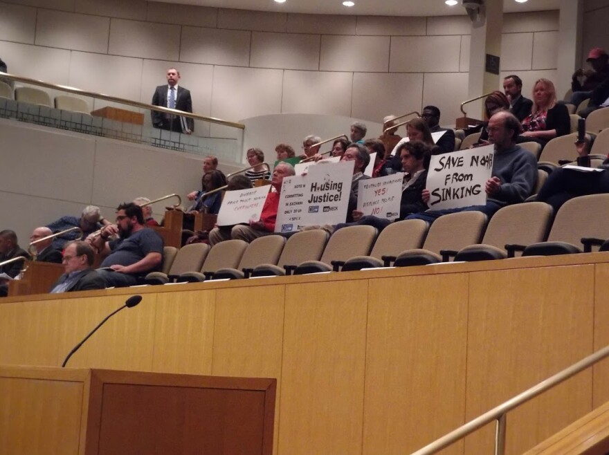 Affordable Housing advocates sat with signs at Monday's council meeting. 