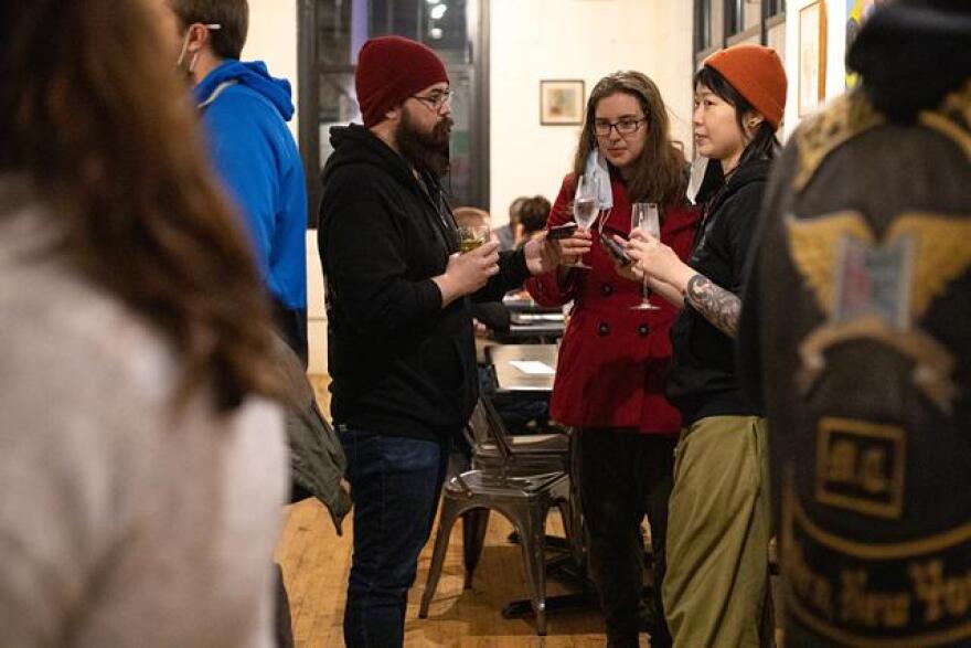 Robb Heffner (in red hat) and Cat Hsu (in orange hat) of Happy Gut Sanctuary and a friend try drinks from AltBar's zero-proof cocktail menu at a pop-up event at Fuego.