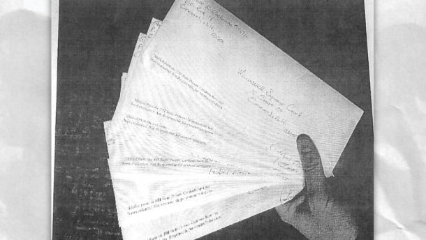 According to a 2023 New Hampshire Fish and Game report, then-Sgt. Thomas Kelley sent this photo to then-Lt. Christopher Masse on Feb. 16, 2021. The report notes that the image shows "a hand holding multiple letters fanned out," with the top envelope addressed to Merrimack Superior Court. "It appears that there is discussion of retribution for the prisoner who wrote and attempted to send the letter," the report states.