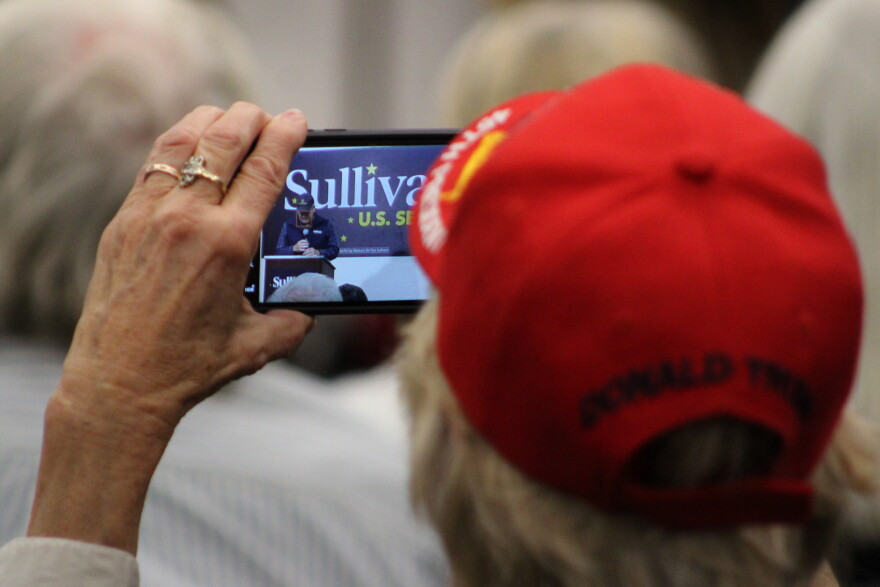 A woman takes a picture of U.S. Sen. Dan Sullivan at a political rally on Saturday, Oct. 17, 2026 in Kenai, Alaska.