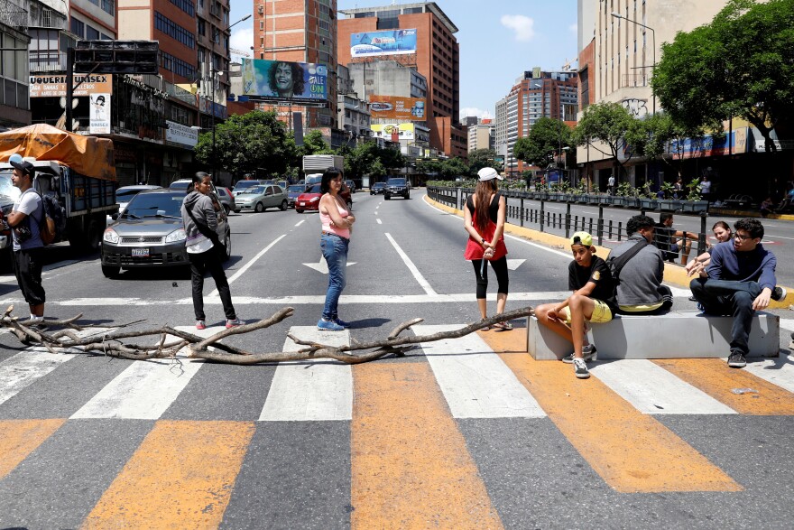 People block a street in Caracas on Sunday to show their anger about the power outage.