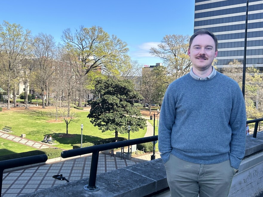 Thomas Yuill, director of Birmingham's Office of Resilience and Sustainability, stands on a balcony at City Hall overlooking Linn Park.