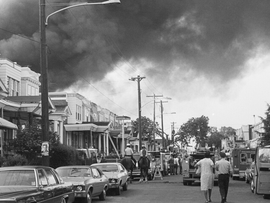 Smoke billows over rowhouses after Philadelphia police bombed the home of Black liberation advocacy group MOVE during a standoff.