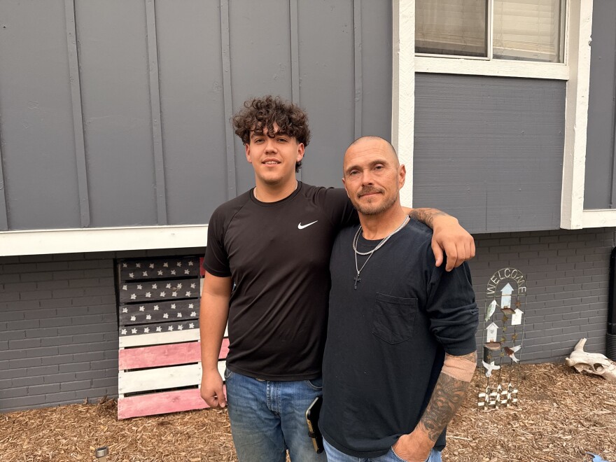 Leland Estes and his dad, Seth, stand outside their home in Kansas City, Kansas. When they couldn't afford baseball fees for Leland, the Finish Strong Foundation stepped in to help.