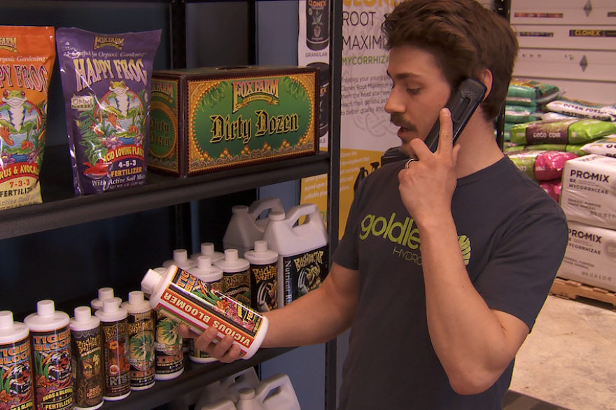 A photo of Goldleaf Hydroponics co-owner Kyle Billman talking on the phone with a customer.