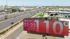 A digital billboard with red background showing 110 degrees and 1:22 p.m. 