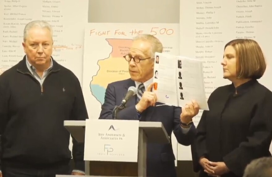 Attorney Jeff Anderson presents a 181-page report compiling sex abuse claims by Illinois priests as alleged victims Joe Iacono and Cindy Yesko look on.