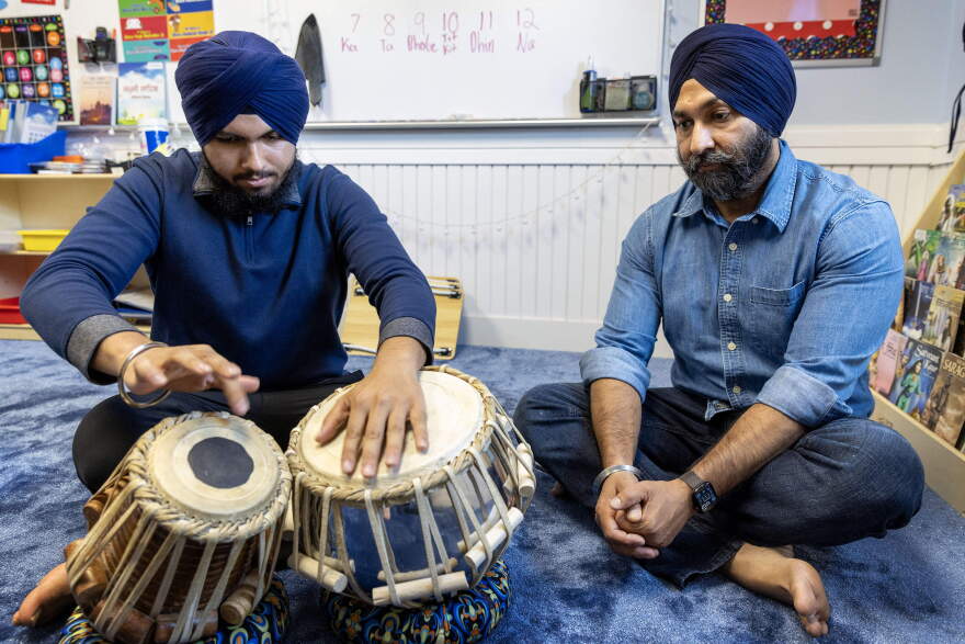 Talvinder Singh watches as his son, Ranveer, plays the tabla at the Gurdwara Guru Nanak Darbar in Medford, Mass.