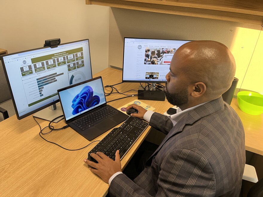 Mecklenburg County's Public Health Director Raynard Washington puls slides that highlight where opioid settlements funds are going.