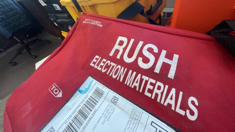Boxes and crates in a room. One says "election materials"