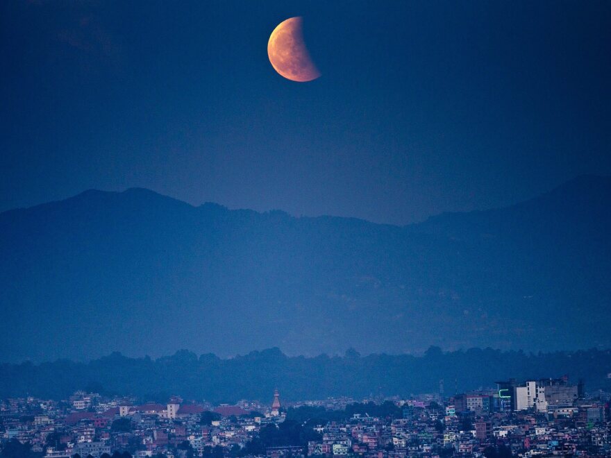 The moon glows red as it rises during a total lunar eclipse as seen in Kathmandu, Nepal.