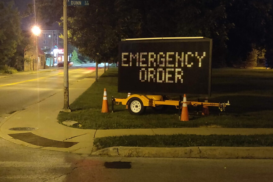 A flashing sign near Indiana University reminds residents that Bloomington is under an emergency order limiting private gatherings to 15 people.