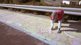 Eli Lilly and Company employee puts finishing touches on Guinness World Record chalk mural.