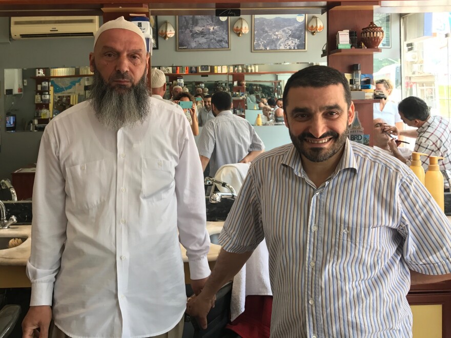 Suat Keceli, left, a retired stockroom worker, and his barber Yasar Ayhan pose in Ayhan's barber shop in Kasimpasa, the Istanbul neighborhood where President Recep Tayyip Erdoğan grew up. Keceli is a conservative Muslim who kept his daughter out of school when headscarves were banned in the classroom.