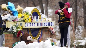 Students hug at a memorial at Oxford High School in Oxford, Mich., Dec. 1, 2021.