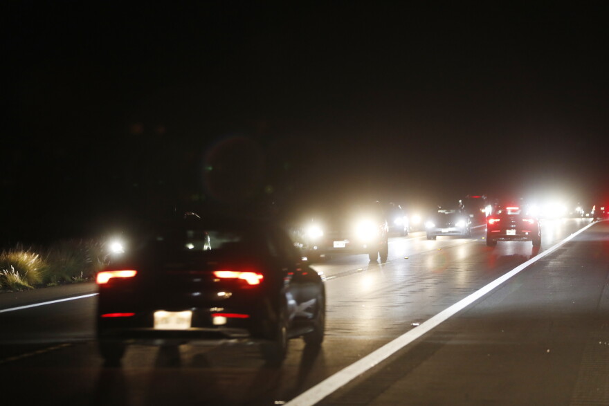 Car travel down Saddle Road near the Maunaloa eruption, Tuesday, Nov. 29, 2022, near Hilo, Hawaiʻi. Despite local authorities enforcing a no parking zone in the area near the eruption site, many spectators are flooding the area and illegally parking on the side of the highway.