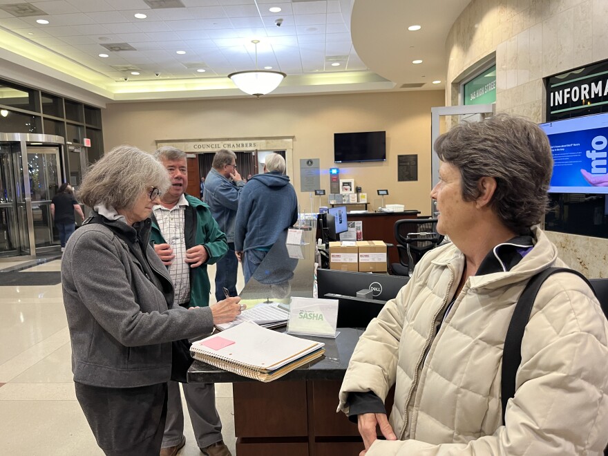 Teri Cunningham shares the petition against the data center with other Hamilton residents after the city council meeting on Nov. 19.